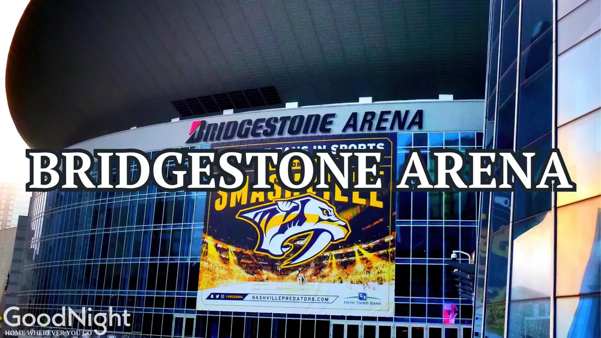 Bridgestone Arena’s impressive exterior, adorned with a large Predators logo and an eye-catching promotional banner, stands as a central nightlife and entertainment destination in downtown Nashville. People can be seen mingling and moving toward the entrance, hinting at the excitement within.