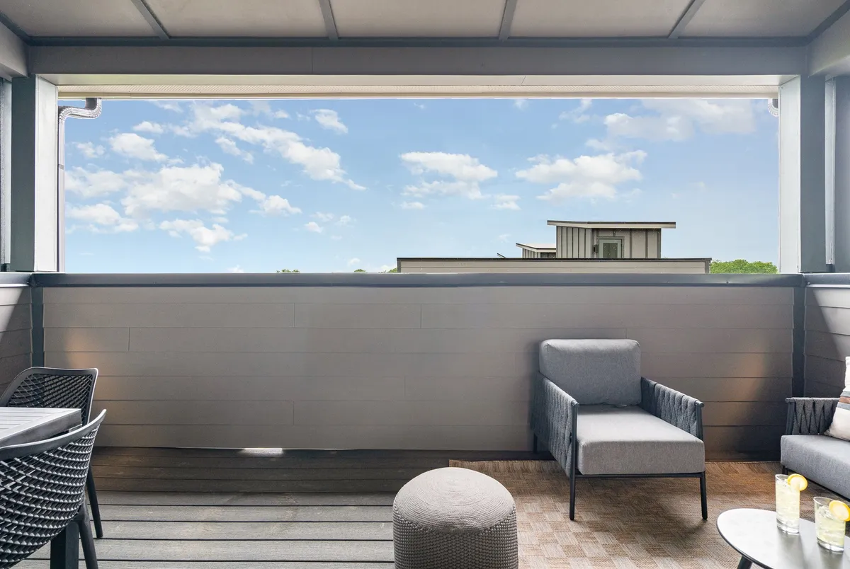 This image captures an inviting outdoor seating area set against a sky view, complete with a decorative table. The mood is peaceful, perfect for enjoying morning coffee, reading, or unwinding while watching the sunset or stargazing at night.